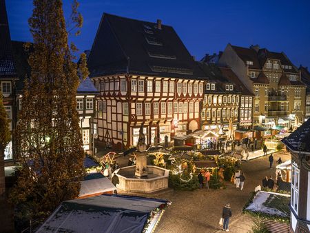 Das beleuchtete Einbecker Weihnachtsdorf mit einigen Besuchern im dunkeln.