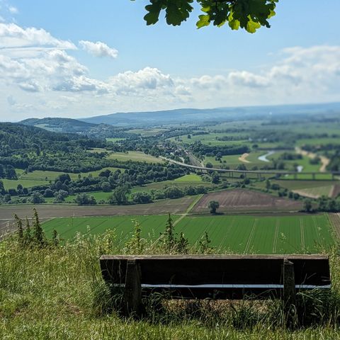 Ein Holzbank dient als Sitzplatz für einen tollen Ausblick in die Landschaft.