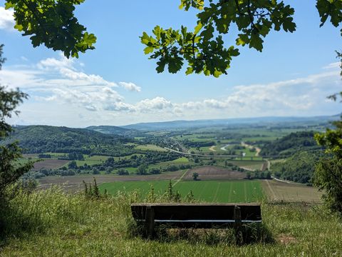 Ein Holzbank dient als Sitzplatz für einen tollen Ausblick in die Landschaft.
