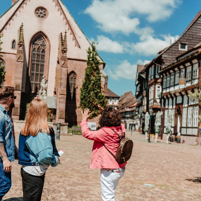 Eine Stadtführerin während einer Führung durch Einbeck mit Gästen auf dem historischen Marktplatz.