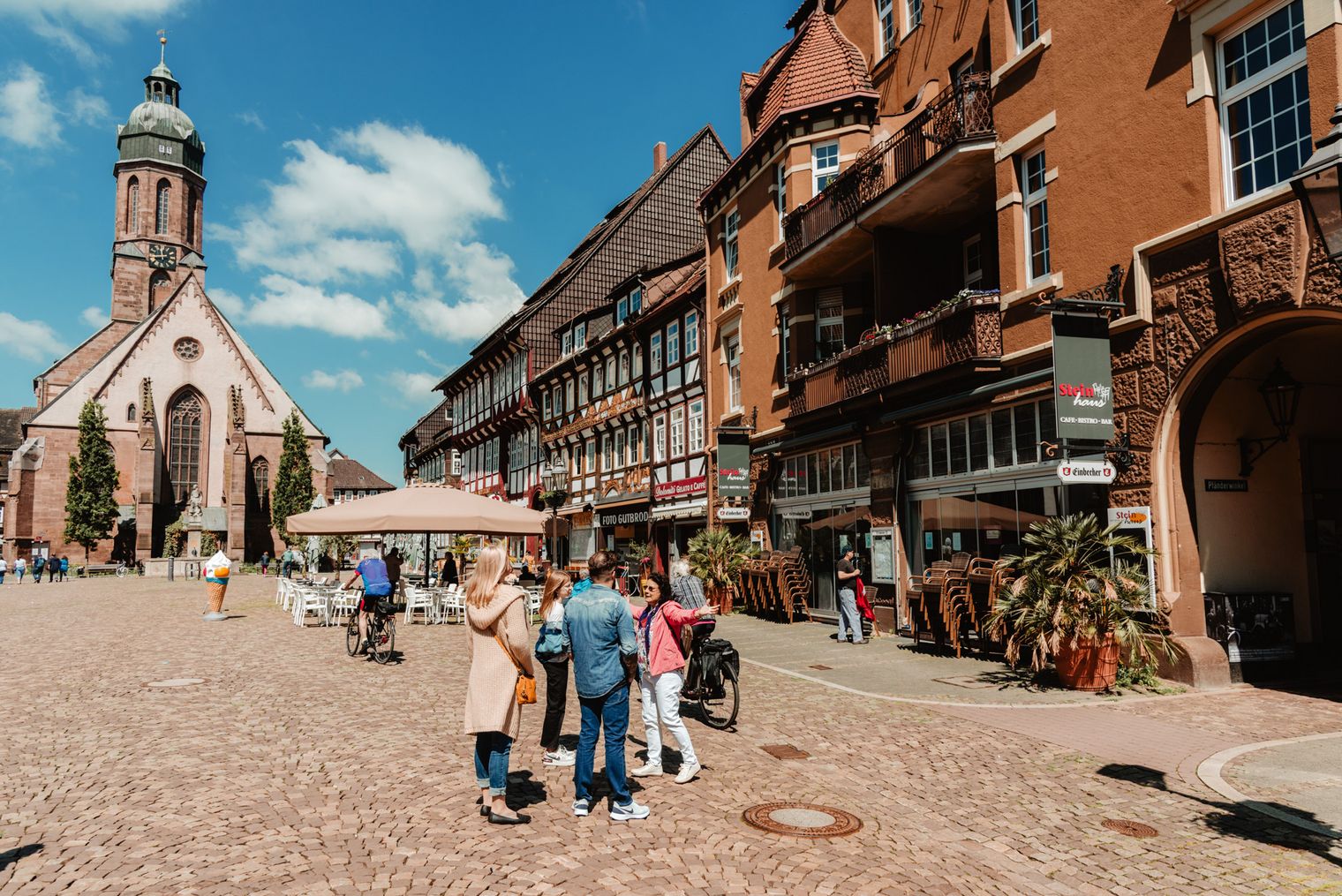 Menschen bei Sonne auf dem Marktplatz bei einer touristischen Führung.