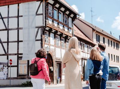 Gästeführerin und 3 Touristen vor dem Wolpeterhaus in der Einbecker Altstadt.