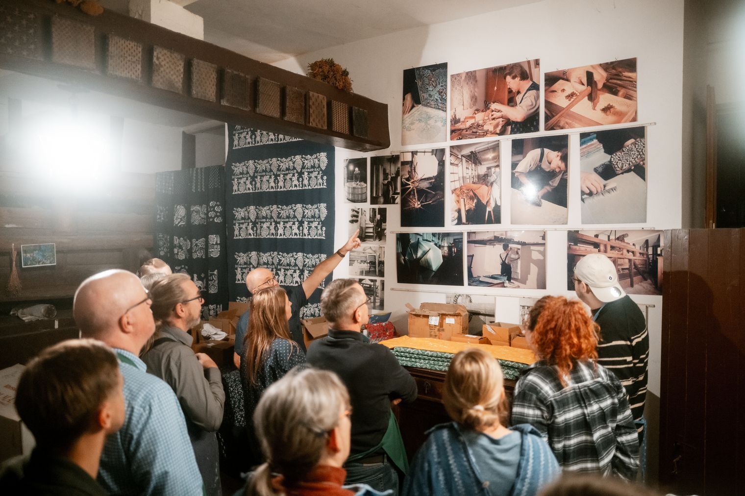 Menschen folgen einer Führung zum traditionellen Blaudruckhandwerk in einem Workshopraum.