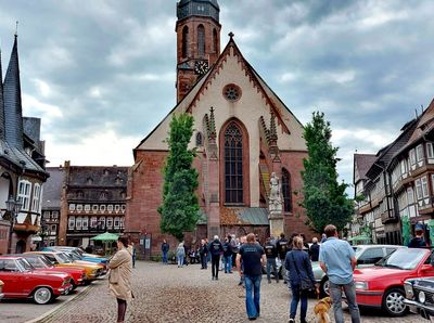 Zu sehen sind Opel-Oldtimer auf dem Einbecker Marktplatz mit herrlicher Fachwerkkulisse bei leicht bewölktem Himmel.