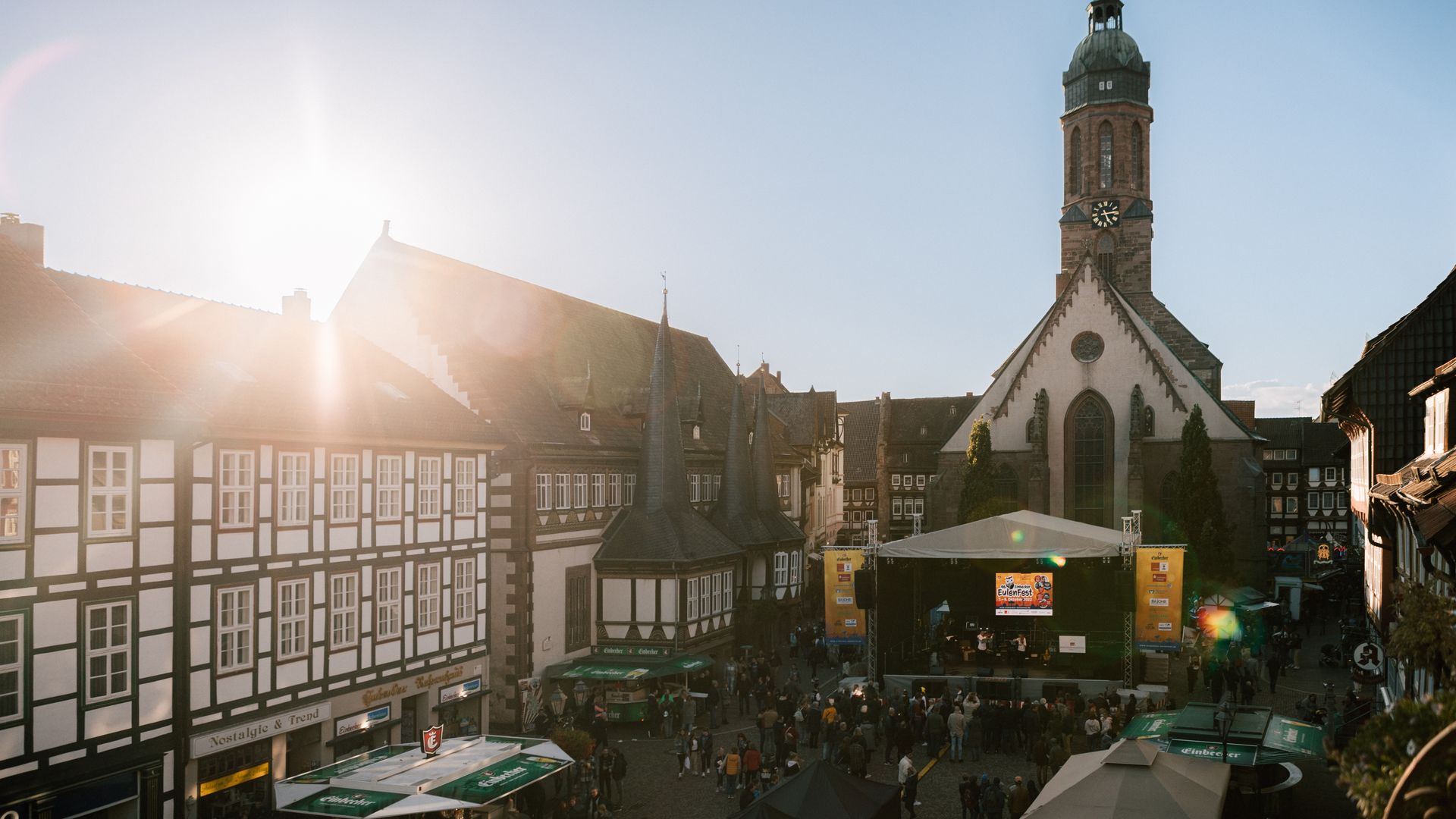 Der Marktplatz während des Einbecker Eulenfestes mit einer Bühne und vielen Menschen bei blauem Himmer und Sonnenschein. 
