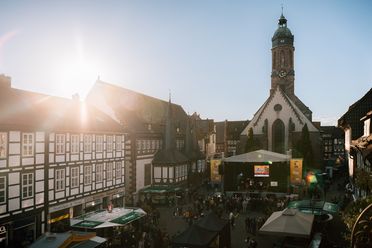Der Marktplatz während des Einbecker Eulenfestes mit einer Bühne und vielen Menschen bei blauem Himmer und Sonnenschein. 