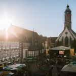 Der Marktplatz während des Einbecker Eulenfestes mit einer Bühne und vielen Menschen bei blauem Himmer und Sonnenschein. 