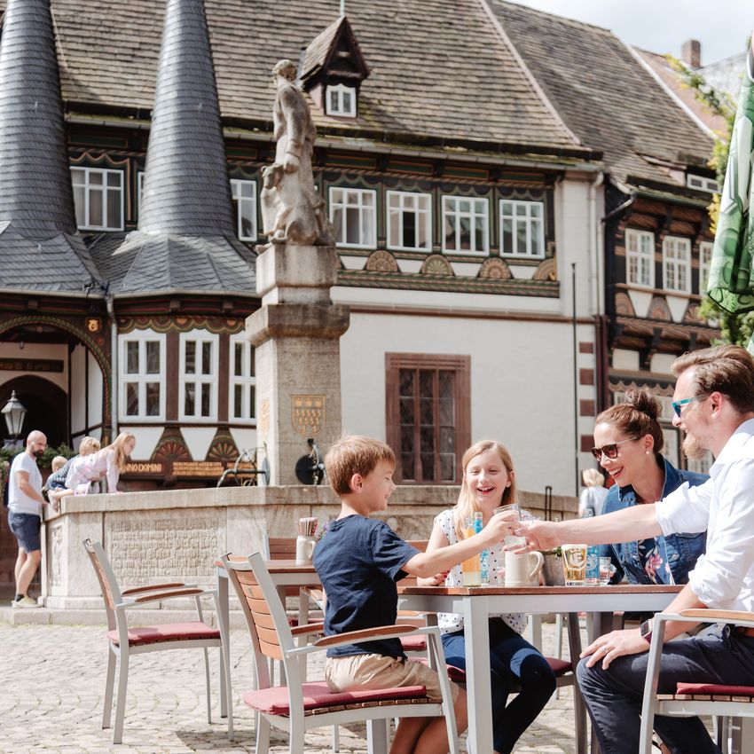Eine Familie sitzt im Außenbereich des Restaurants Brodhaus auf dem Marktplatz. Sie essen und trinken.