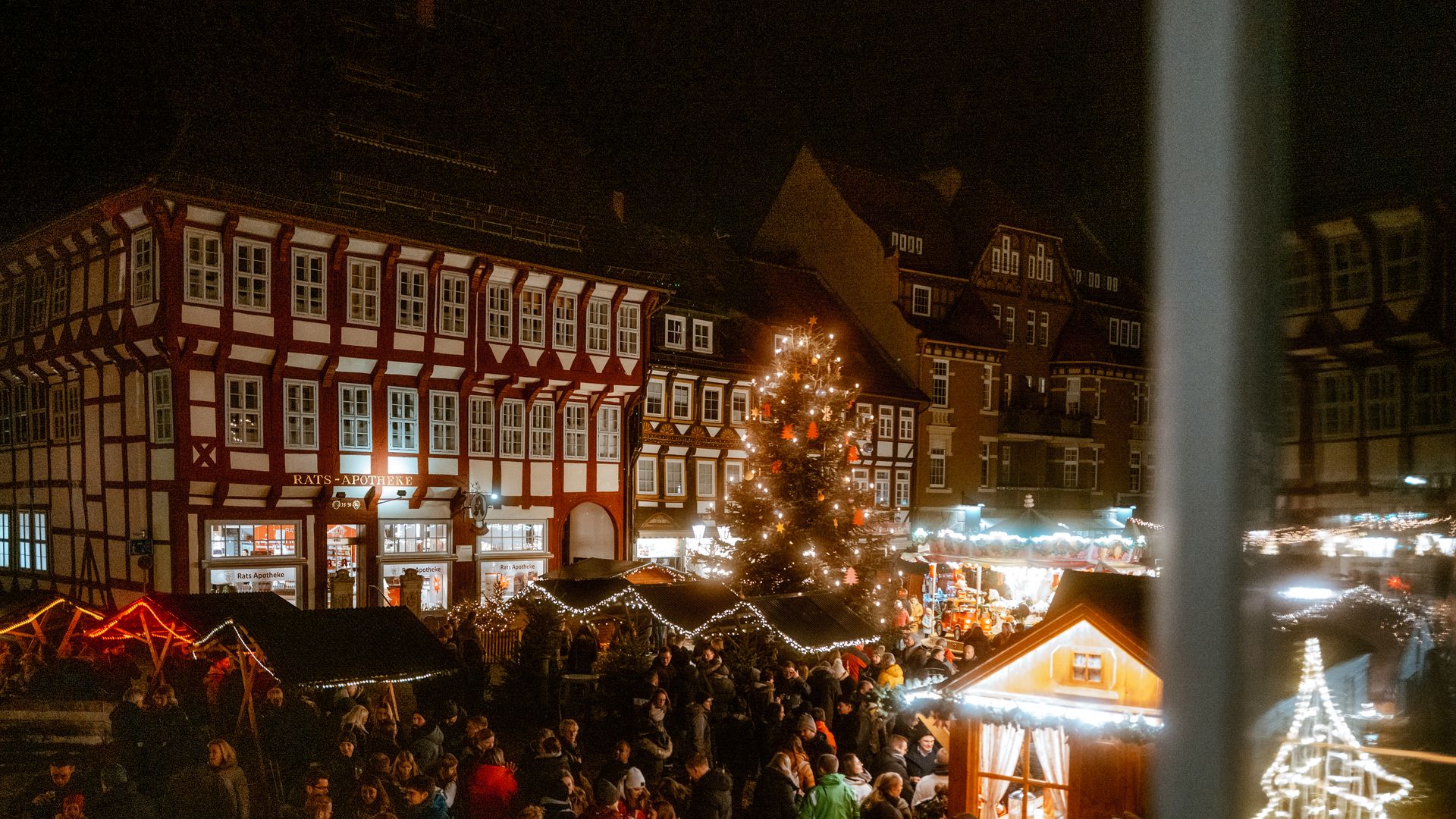 Das belebte Weihnachtsdorf auf dem Einbecker Marktplatz mit verschiedenen Ständen und vielen Menschen.