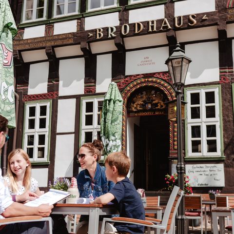 Eine Familie mit zwei Kindern sitzt an einem Tisch vor dem Brodhaus.