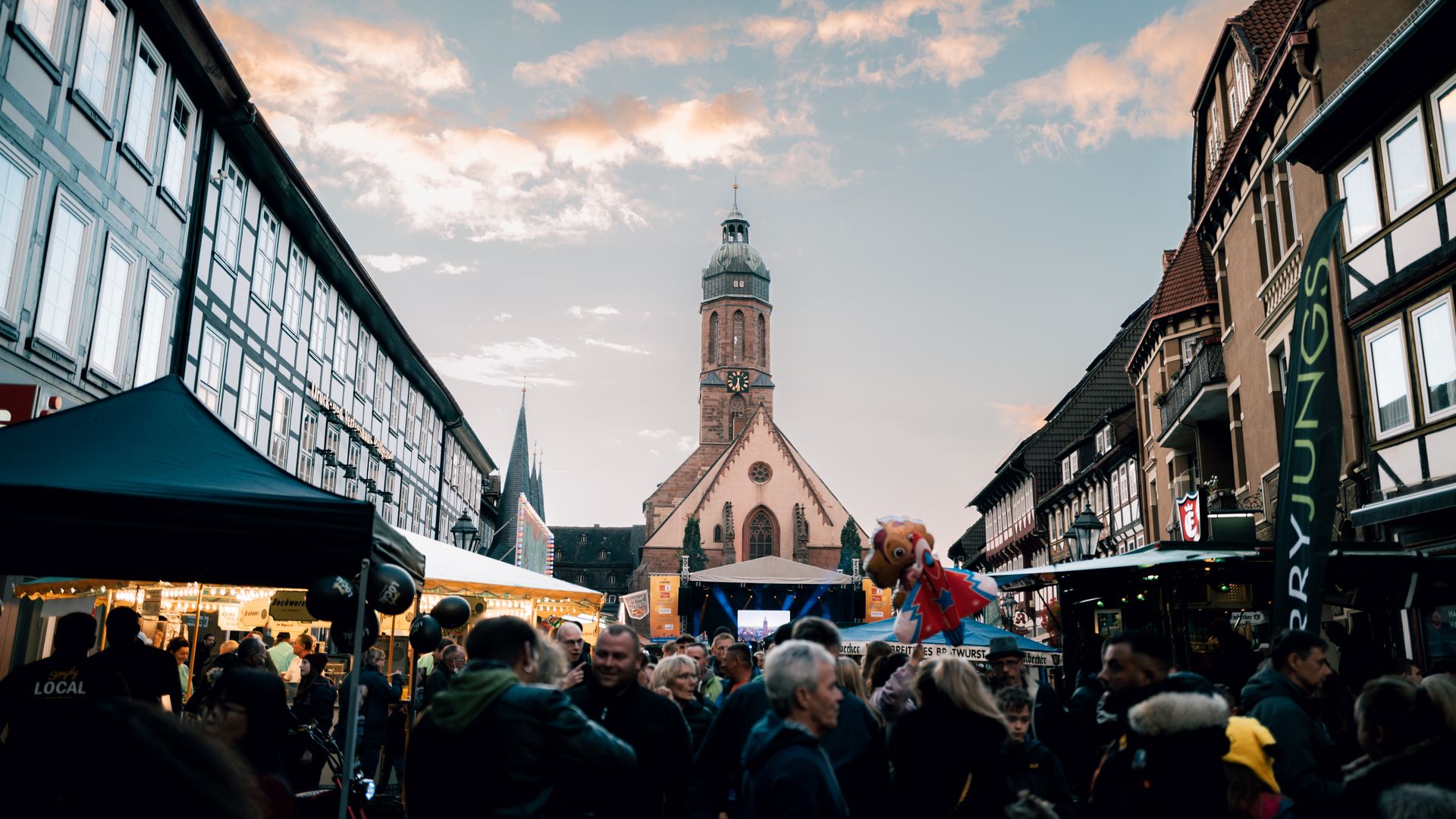 Mit Menschen gefüllter Markplaltz in Einbeck. Mit Sicht auf den Turm der Einbecker Marktkirche.