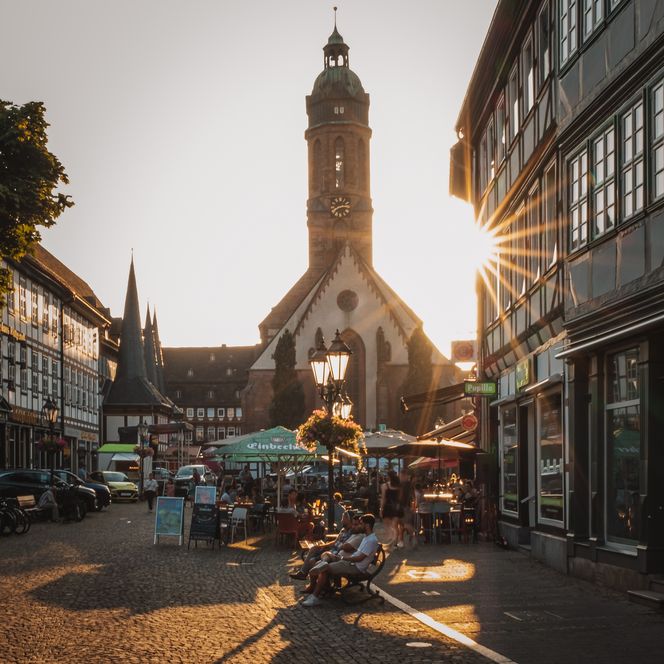 Sonnenuntergang auf dem historischen Marktplatz mit Fachwerkhäusern, Straßencafés und der Marktkirche im Hintergrund