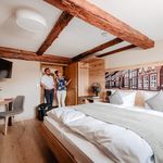 2 Menschen in einem Hotelzimmer im Fachwerkstil.