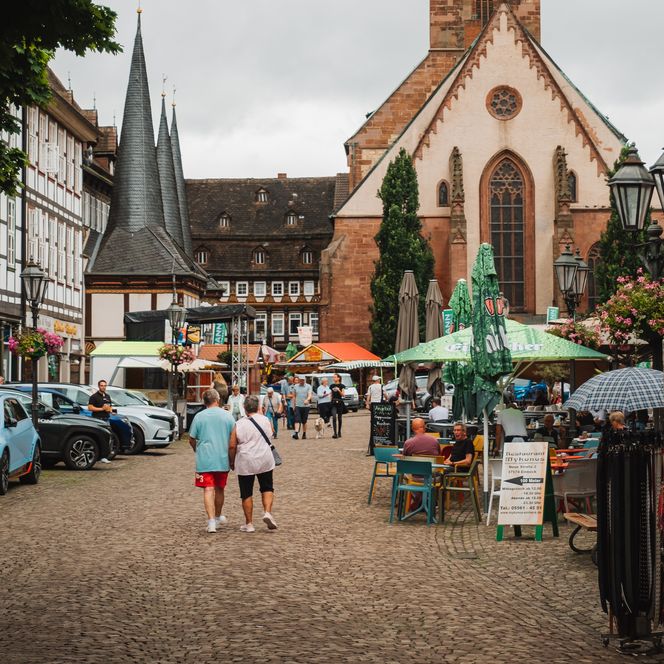 Einbecker Marktplatz mit dem belebten Wochenmarkt vor der Kirche. 