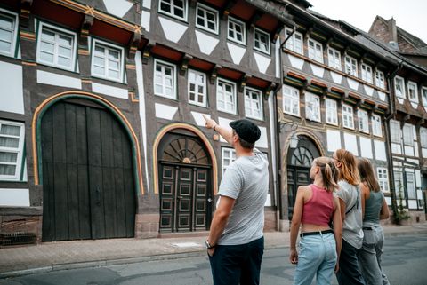 Familie mit zwei Kindern in der Tiedexer Straße. Der Vater zeigt auf einen schiefen Torbogen.