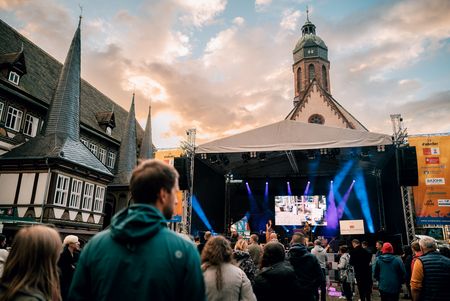 Publikum vor beleuchteter Bühne neben Fachwerkhäusern und Kirchturm bei der Veranstaltung des Eulenfestes.