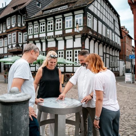 Vier Personen betrachten ein Fass des Bierpfades auf dem Einbecker Marktplatz.