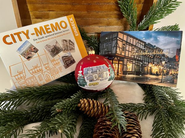 Die neuen Souvenirs City-Memo, Weihnachtsbaumkugel und Adventskalender ausgestellt in einer Holztruhe.