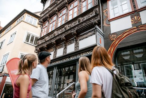 Eine Familie mit zwei Töchtern steht vor dem Eickeschen Haus. Ihre Blicke sind auf das Fachwerkhaus gerichtet.