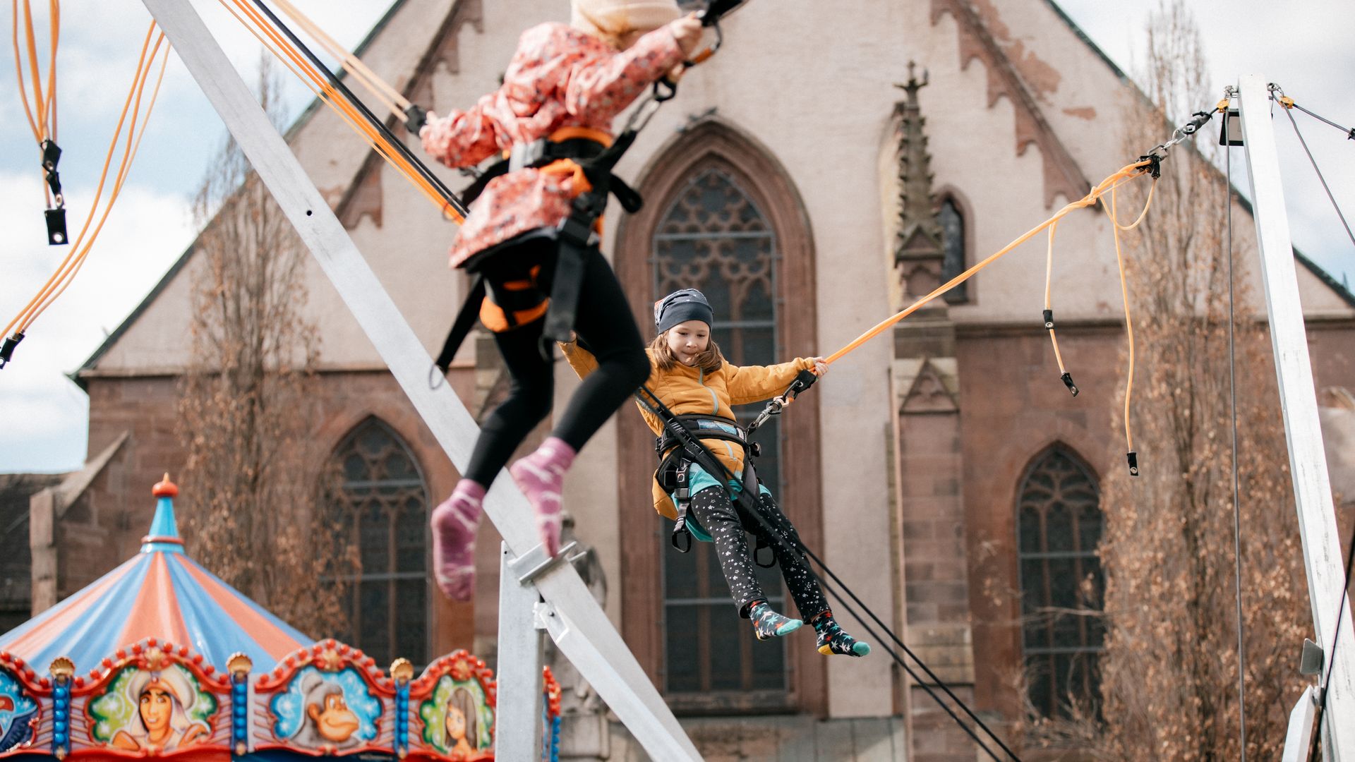 Kinder in einem Fahrgeschäft mit Bungee-Seilen.